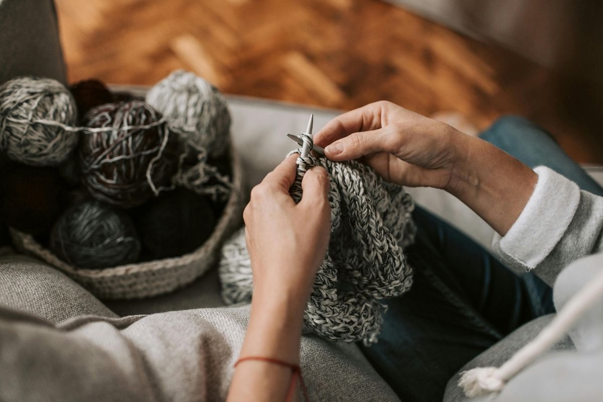 A Person Knitting Yarn with Knitting Needles